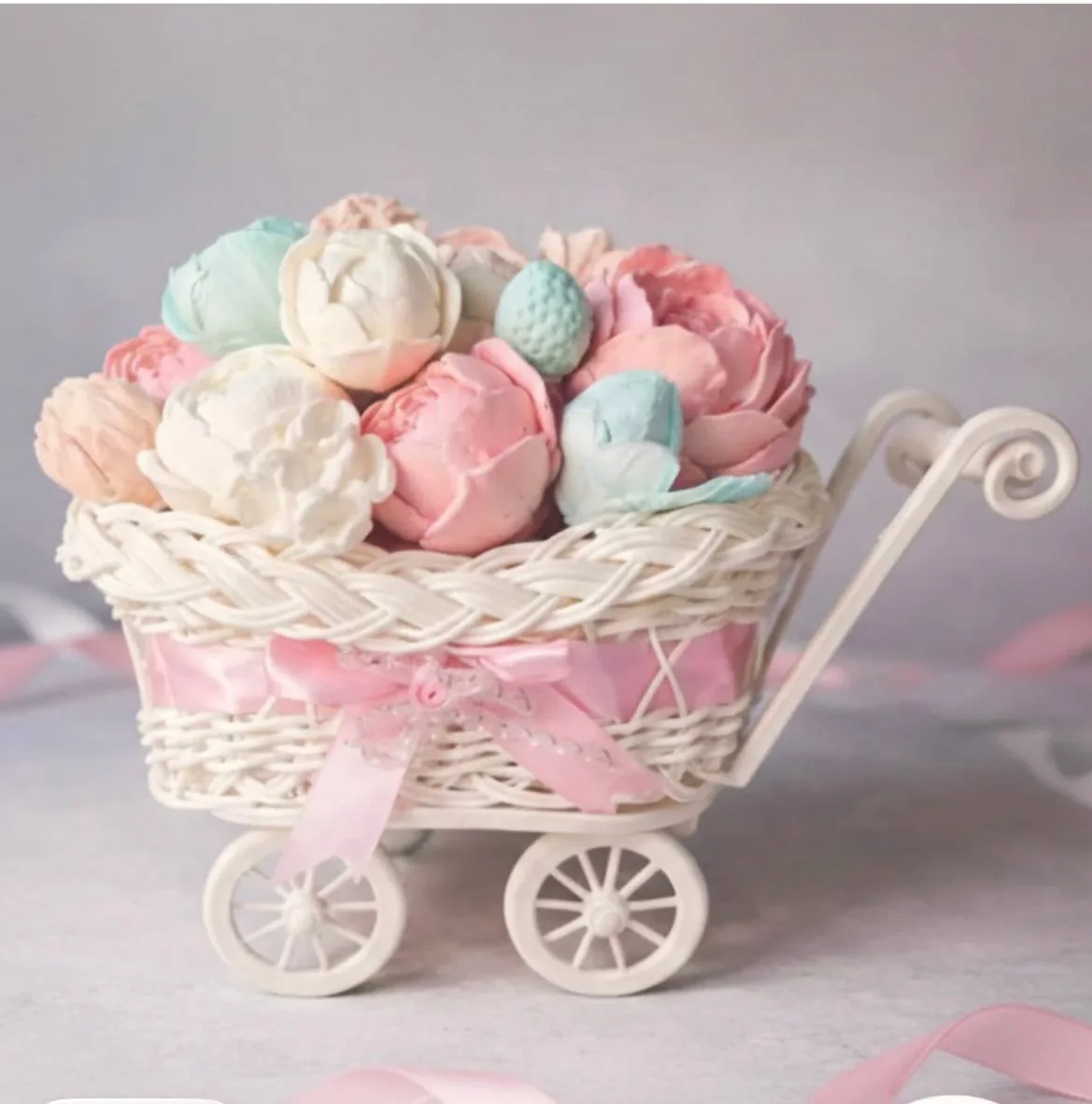 Pastel marshmallow flowers in a miniature pram for a new baby